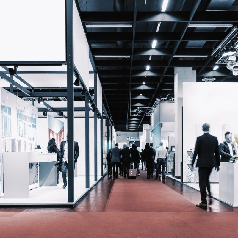 business people walking between trade show booths. ideal for web